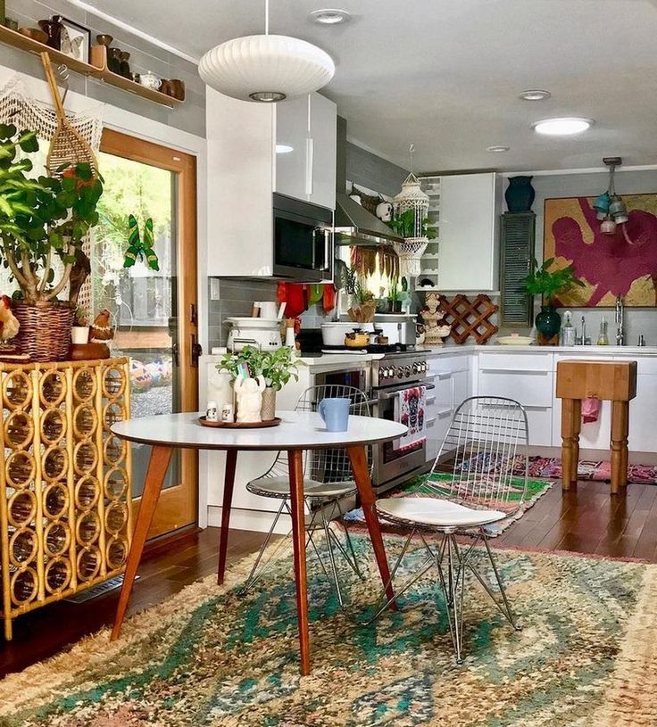 a living room filled with furniture next to a kitchen and dining room table covered in potted plants