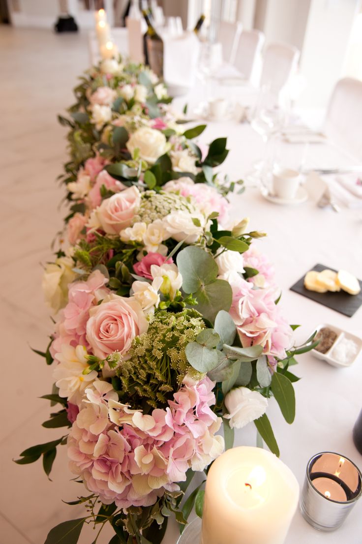 a long table with flowers and candles on it