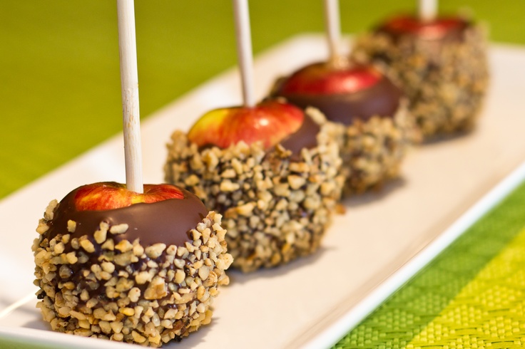 there are apples that have been dipped with chocolate and sprinkles on them