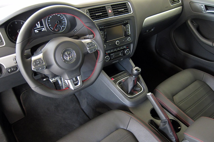 the interior of a car with dashboard controls and steering wheel, dash lights and center console