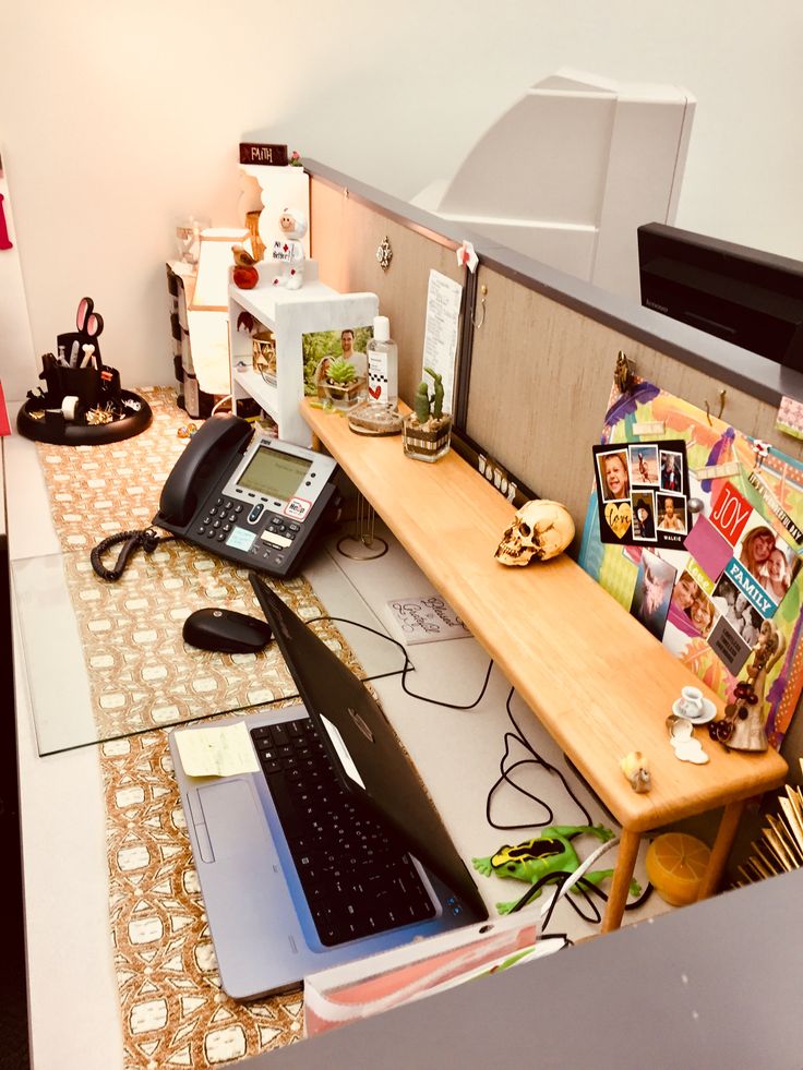 a desk with a laptop, phone and other items on it