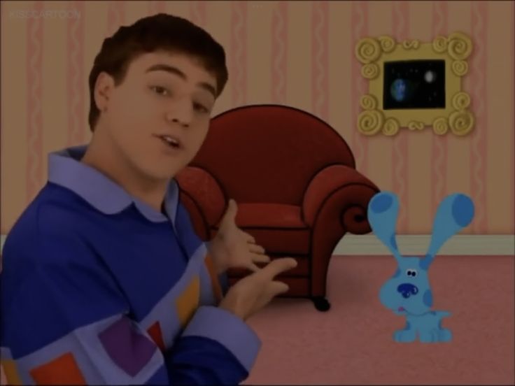 a young man is standing in front of a red chair with a blue bunny on it