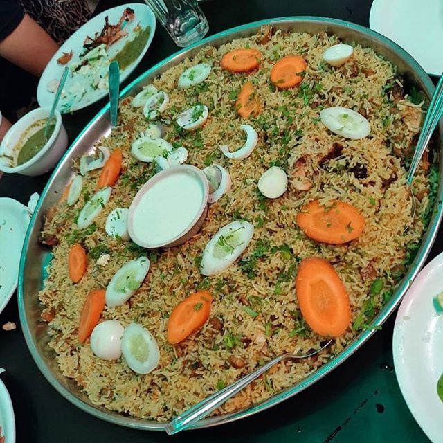 a large platter filled with rice and veggies on top of a table