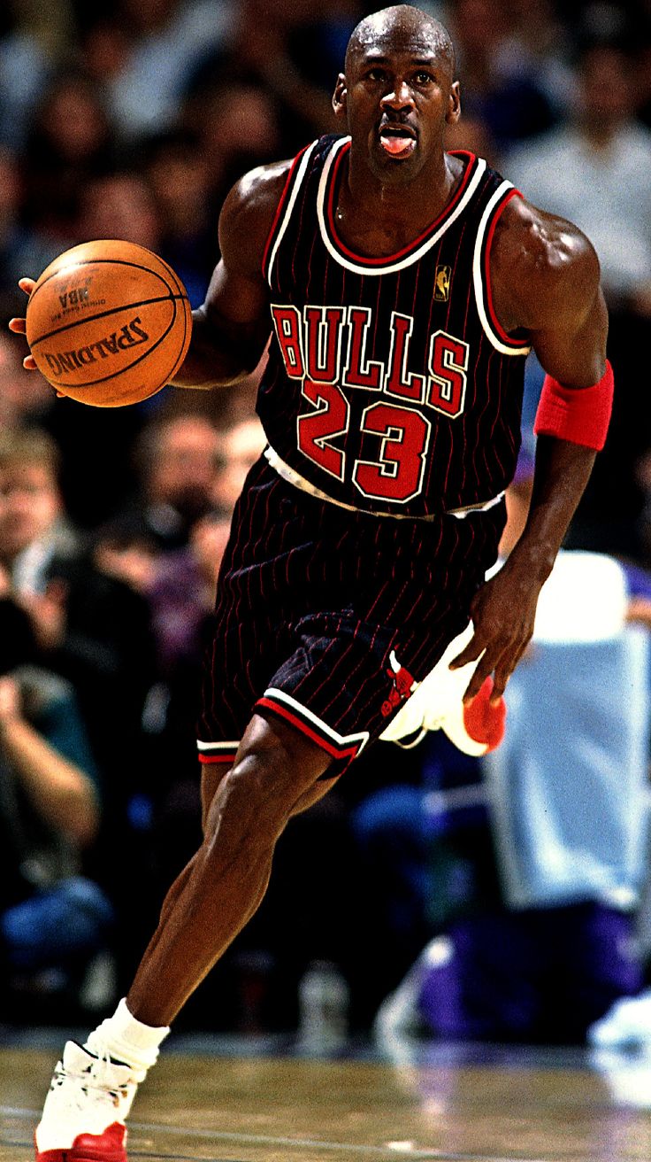 a basketball player dribbling the ball during a game with fans in the stands