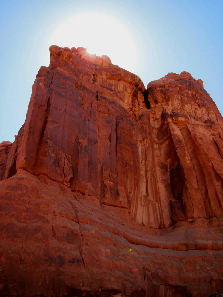 the sun shines brightly on red rock formations