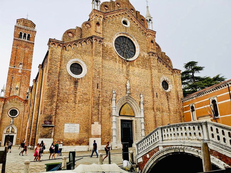 people walking around in front of an old church