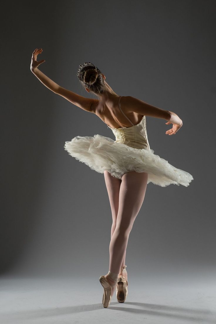 a ballerina in a white tutu posing for the camera