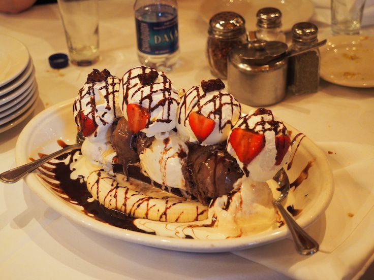 a white plate topped with ice cream and strawberries