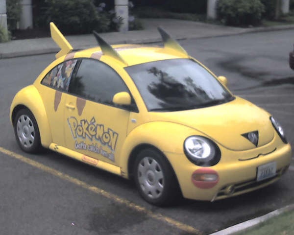 a small yellow car parked in a parking lot