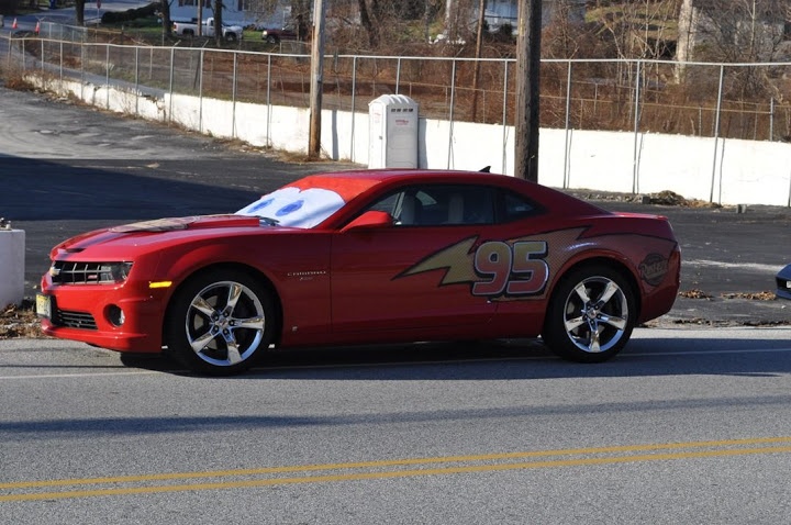 a red sports car with the number 95 painted on it's side parked in front of a parking meter