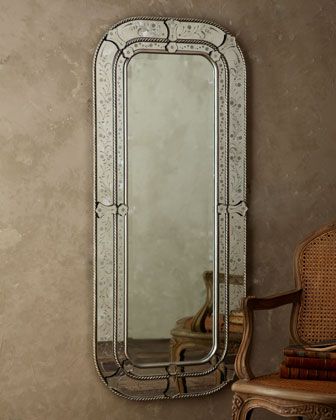 a mirror sitting on top of a wall next to a chair