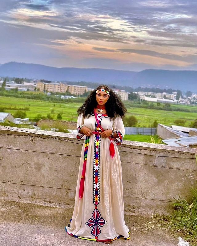 The Habesha dress, also known as Habesha Kemis, is a vibrant example of Ethiopian traditional dress. Celebrated during the Ashenda festival, this culturally rich attire showcases intricate designs and bright colors, reflecting the joyous spirit and heritage of Ethiopia. Material Cotton Thread Estimated delivery : 1 week to 2 weeks Contact WhatsApp +1(304)-306-2784Email: contact@ethiopian.store Ceremonial Bohemian Maxi Dress With Traditional Patterns, Bohemian Maxi Dress With Traditional Patterns For Ceremonial Occasions, Traditional Long Sleeve Maxi Dress For Festivals, Traditional Pattern Long Maxi Dress For Festivals, Traditional Patterned Long Maxi Dress For Festivals, Traditional Maxi Dress With Traditional Patterns, Traditional Maxi Dress With Drape For Festivals, Long Traditional Dresses With Patterns, Traditional Long Dresses For Transitional Season