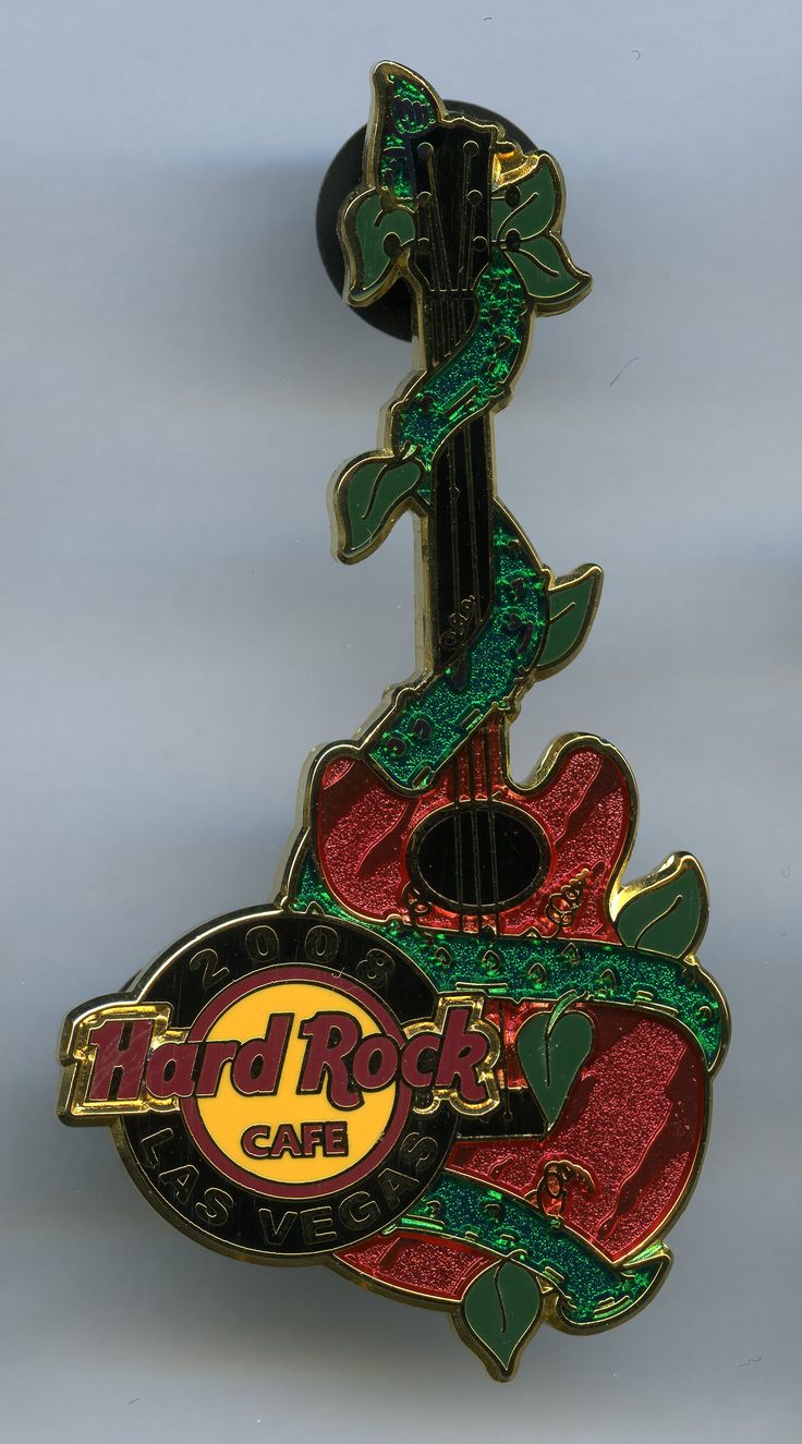 a red and green guitar shaped pin with the word hard rock cafe on it's back