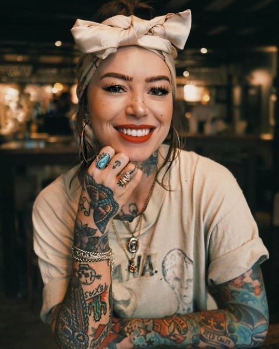 a woman with tattoos and a bow in her hair