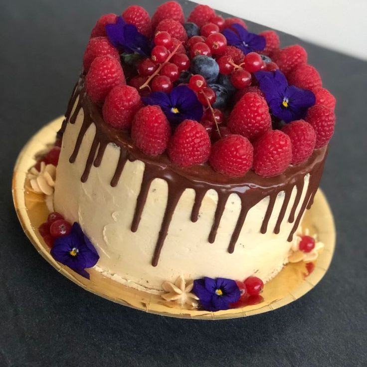 a cake with berries and chocolate drizzled on top