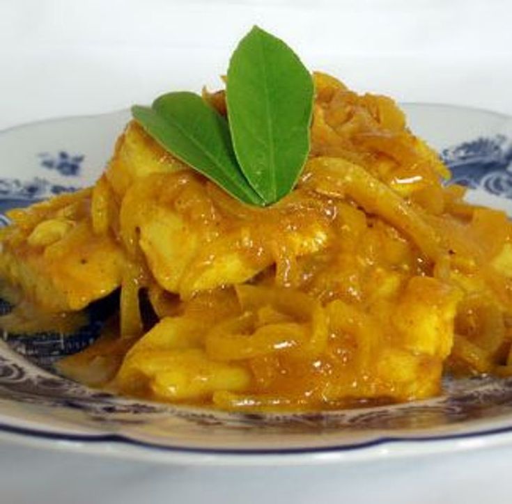 a close up of a plate of food with meat and vegetables in sauce on it