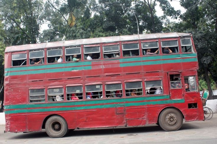 an old double decker bus with people on it