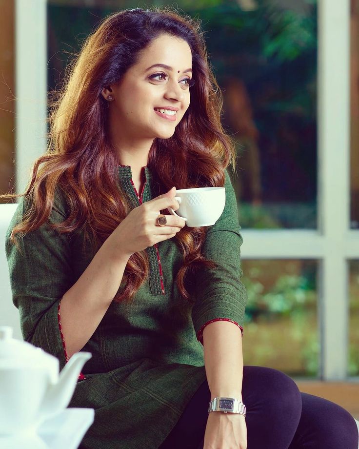 a woman sitting on a couch holding a coffee cup