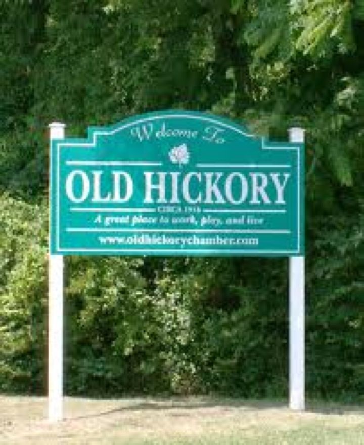 a welcome sign for old hickory in front of some trees and bushes on a sunny day