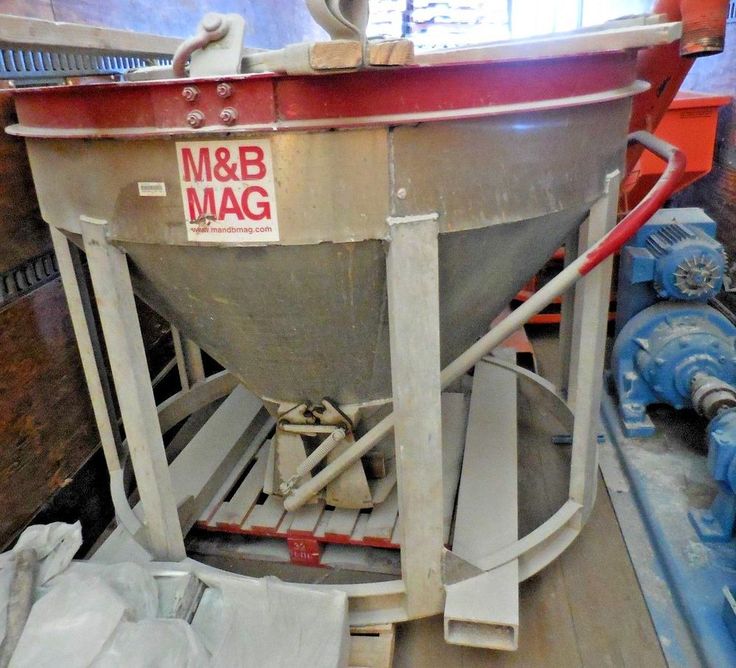 a large metal mixer sitting on top of a wooden floor