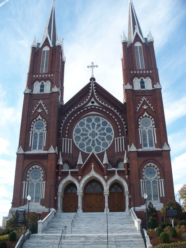 an old church with stairs leading up to the front door and two steeples on each side