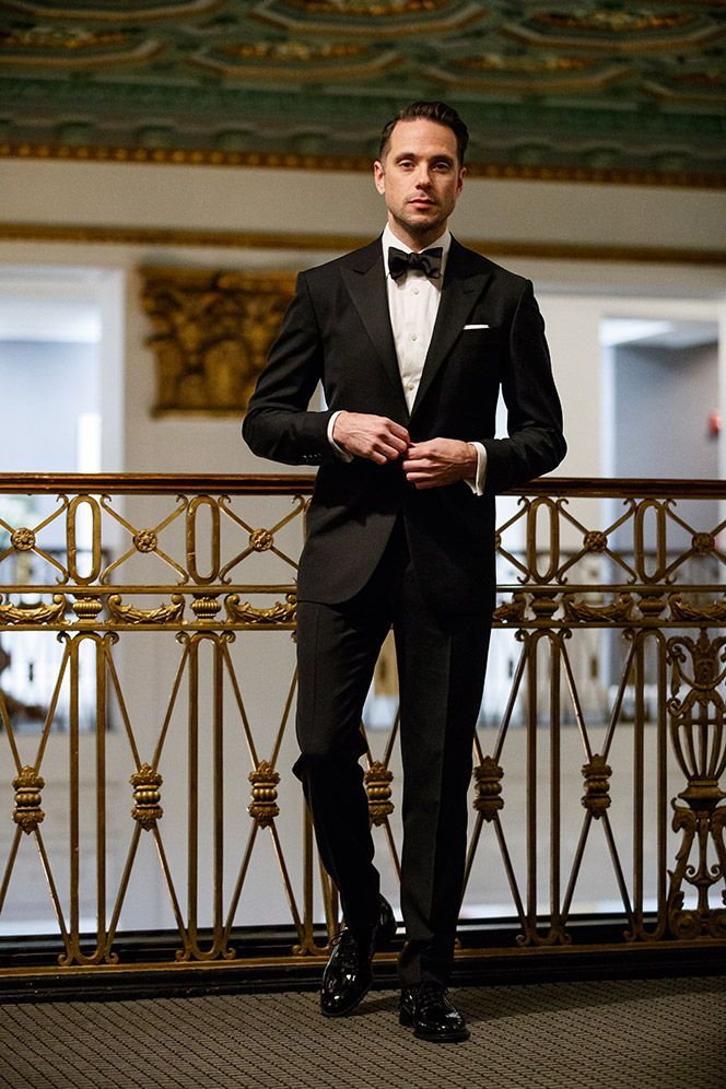 a man in a tuxedo standing on a balcony