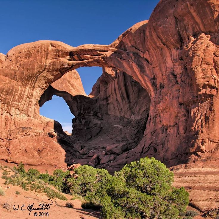 an arch shaped rock formation in the desert