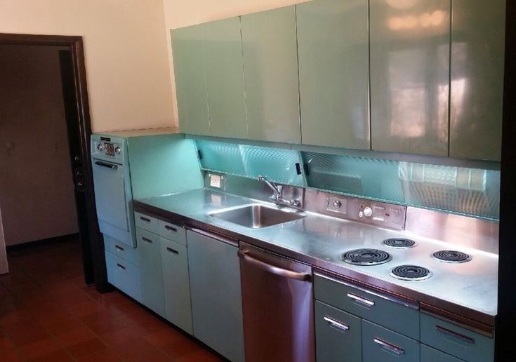 an empty kitchen with stainless steel appliances and blue counter tops is seen in this image