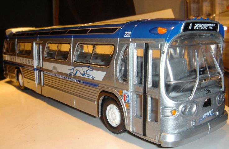 a silver and blue bus is sitting on a white counter top with other items in the background