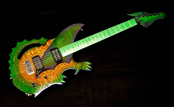 a green and orange guitar shaped like a dragon