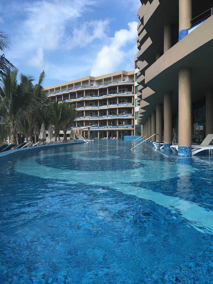 an empty swimming pool in front of a hotel