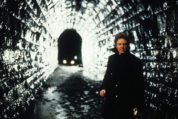 a man standing in the middle of a tunnel with light coming from it's entrance