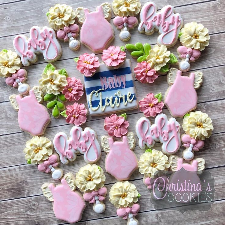 baby shower cookies decorated with pink and white icing on a wooden ...