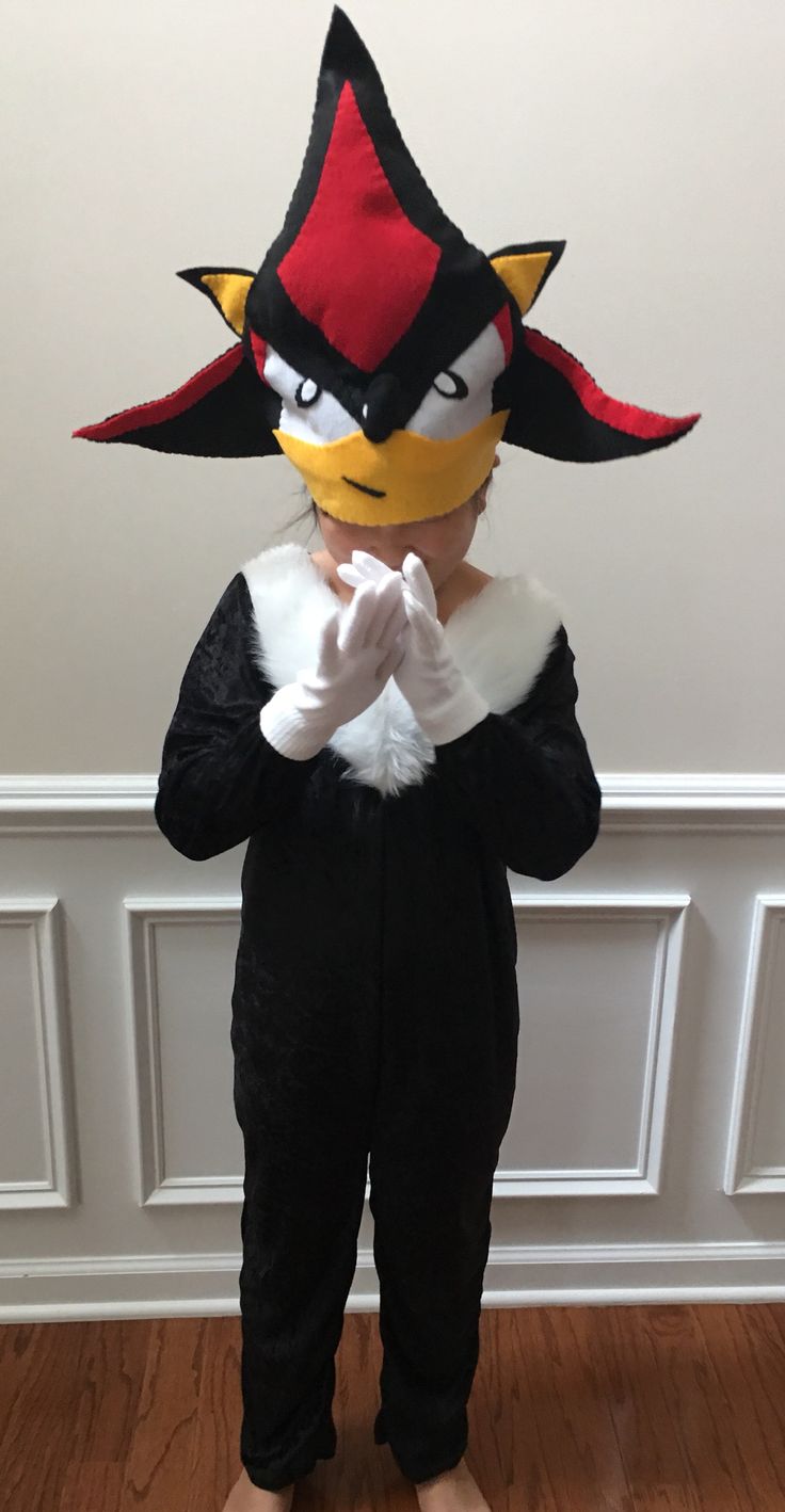 a person in a cat costume standing on a hard wood floor with their hands together