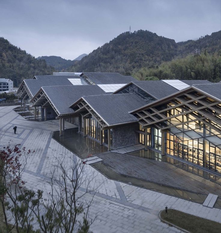 an aerial view of a building with mountains in the background