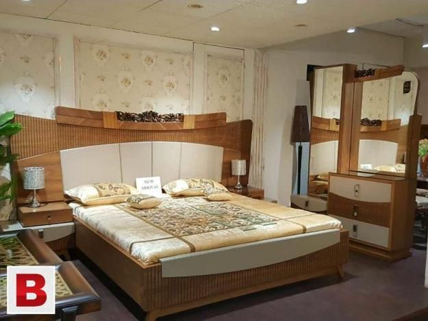 a bed room with a neatly made bed and dressers