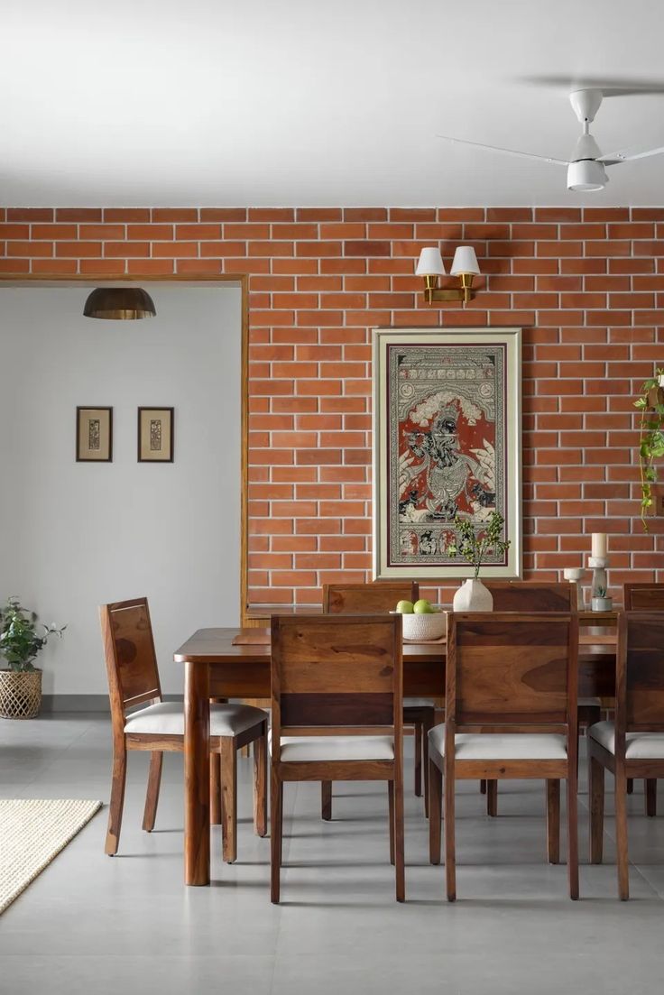 a dining room table with chairs and a brick wall in the backround area