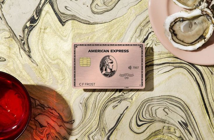 an american express credit card sitting on top of a table next to some oysters