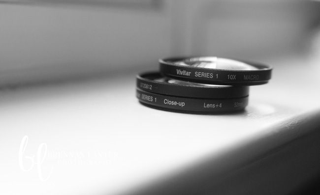 two black camera lenses sitting on top of a window sill