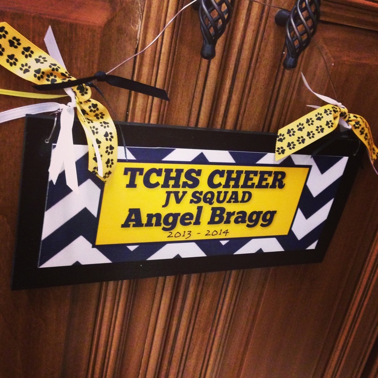 a sign hanging from the side of a wooden door that says tchs cheer iv squad angel brag