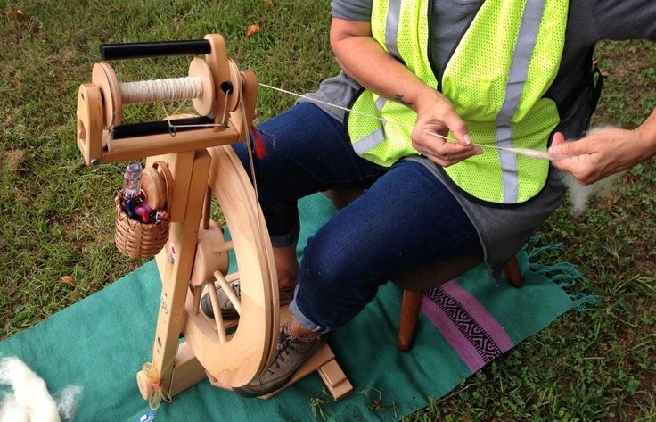 two people are sitting on the ground working on an object that is being made out of wood