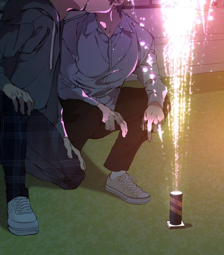 a man sitting on the ground next to a can with fireworks coming out of it