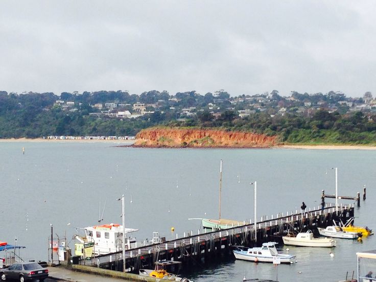 several boats are docked at the pier in the water