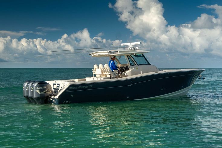 a black and white boat in the middle of the ocean with two people on it