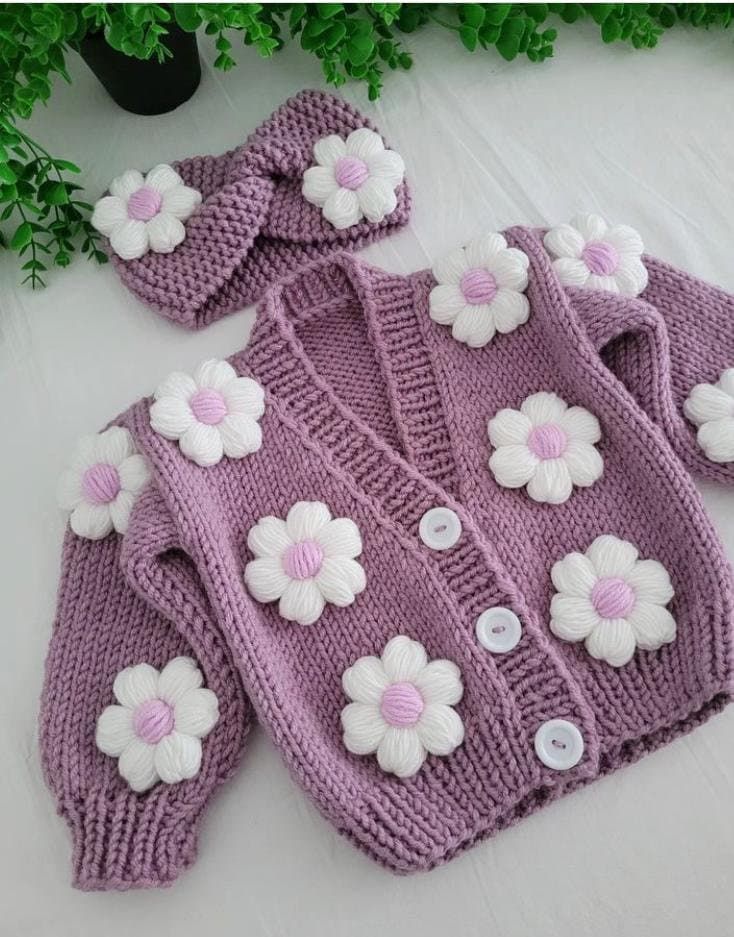 a knitted sweater and hat with flowers on it