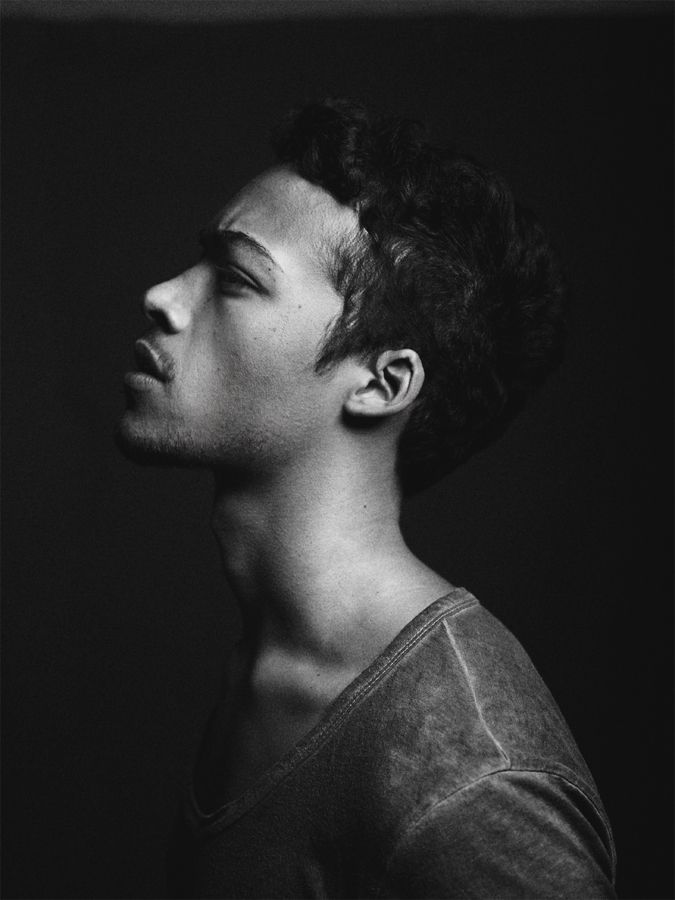 a black and white photo of a man with his head turned to the side looking up