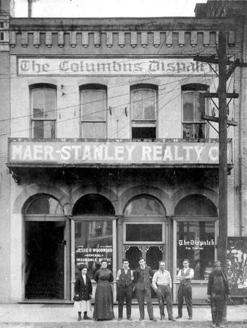 an old black and white photo of people standing in front of a building