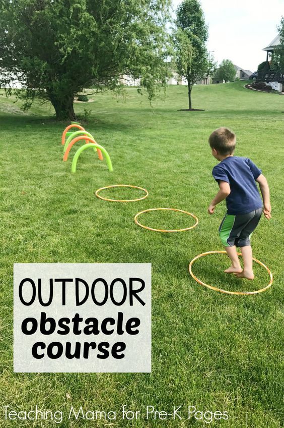 a young boy is playing with an outdoor obstacle course