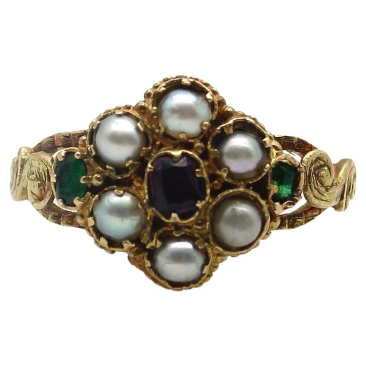 Here at Kirsten’s Corner, we have a sweet spot for these early Victorian flower rings. This 15k gold ring is reminiscent of a Forget-Me-Not flower, a popular motif in the Victorian era. The pearl flower petals in the ring represent tears and capture the romance in our hearts. A central garnet sits delicately amidst a lacy background, while two Old Emerald Cut emeralds add a pop of green to each side of the flower. Each stone is prong set into an early Victorian setting that was traditional for these types of rings. Along the sides is scrolling foliate, hand detailed to look like leaves. A lovely engraving goes all the way around the band of the ring, even detailing the edges of the band. Circa 1850, this is a very old ring that conveys sentimentality and everlasting love. The garnet measur 16th Century Jewelry, Antique Engagement Rings Victorian, Antique Emerald Engagement Ring, Victorian Wedding Ring, Green Engagement Rings, Antique Rings Victorian, Victorian Style Rings, Avon Rings, Art Nouveau Ring