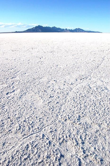 an expanse of snow with mountains in the distance